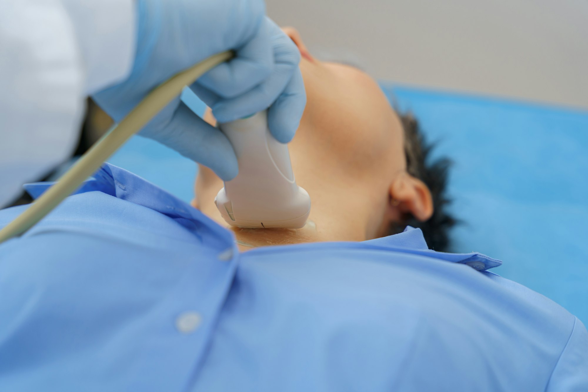 Adult woman having thyroid exam with ultrasound at doctor's office. Healthcare concept