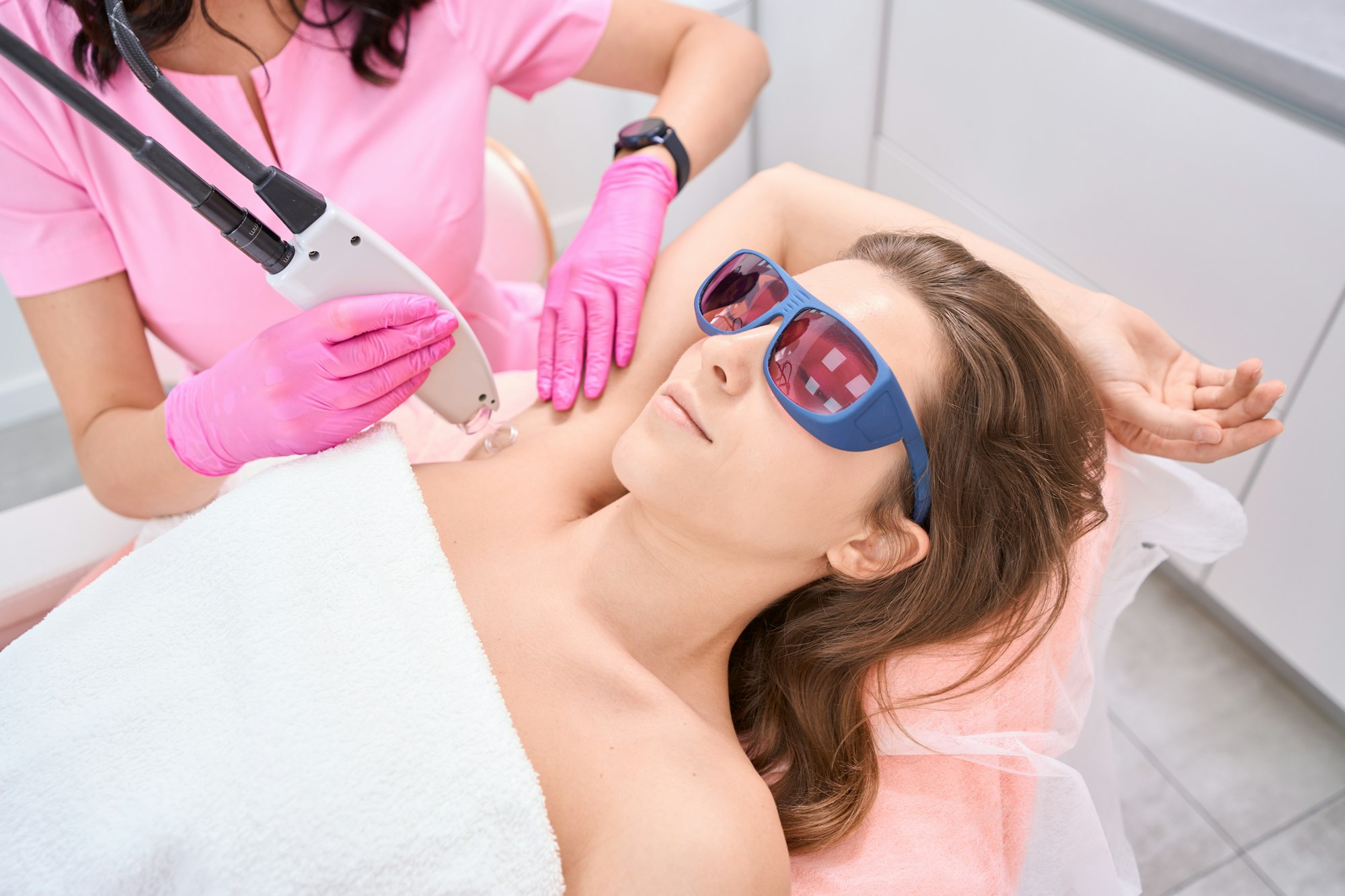 Lady raised right hand up during laser hair removal procedure